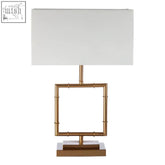 Zofie table lamp with gold finish, white linen shade, and stepped plinth square frame base for elegant lighting