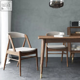 Modern zonka chair with warm wood angled legs and light gray upholstered seat and backrest