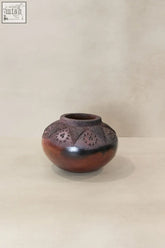 Handcrafted zulu pot with intricate geometric and floral patterns in rich glossy brown terracotta from south africa
