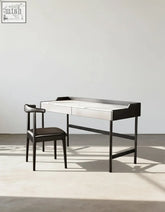 Modern black-framed zuriel office desk with white sintered stone top and two drawers paired with black leather chair