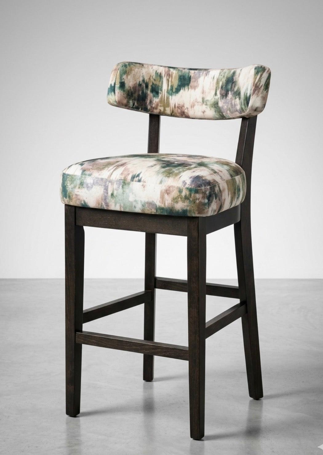 Ninna tall stool with dark wood frame and cushioned seat and back in soft green and beige floral fabric
