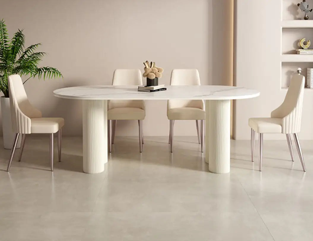 White marble oval dining table with fluted cylindrical legs