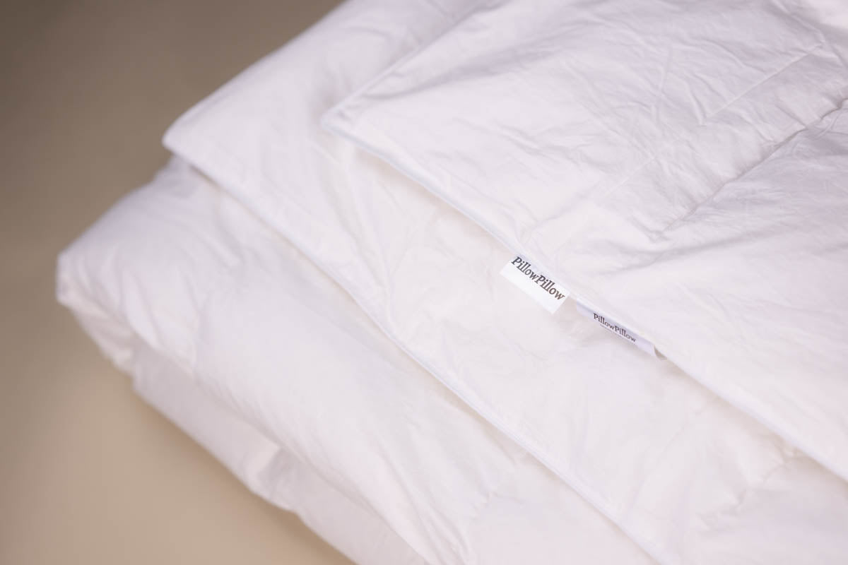 White goose down duvet with 10.5 tog rating featuring a soft white pillow quilt and subtle stitching details