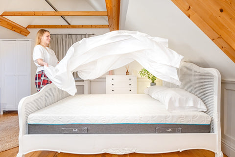 White woven cane bed frame with gray and white lift mattress and 100% organic bamboo flat bed sheets