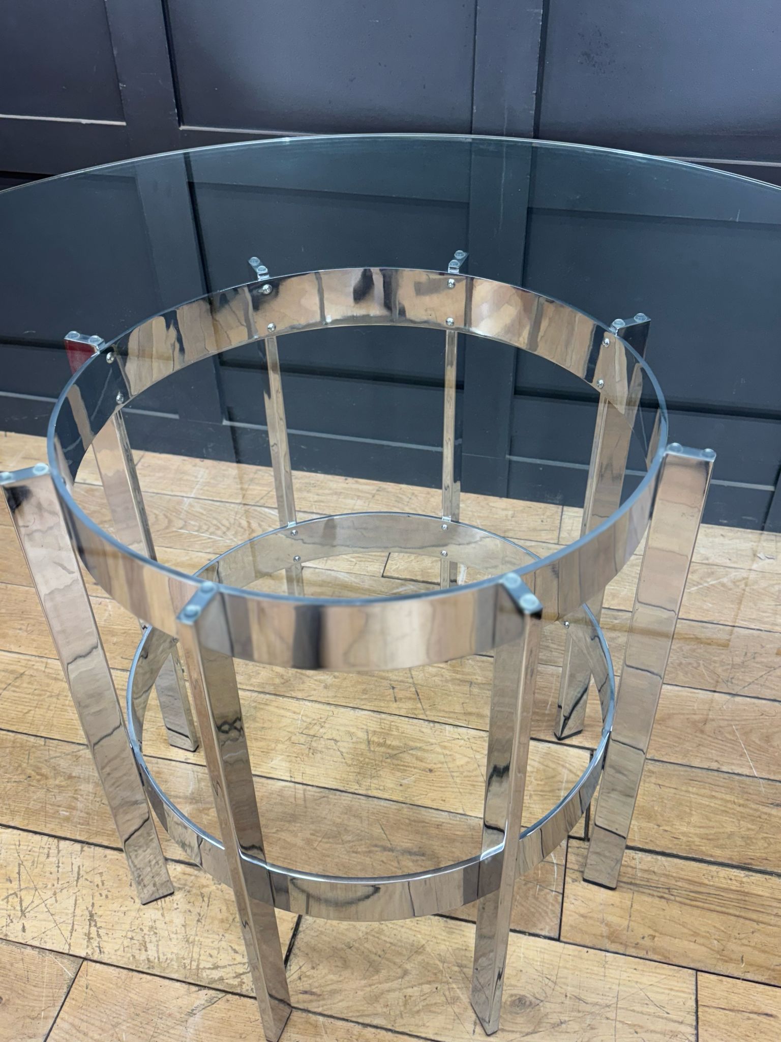 Shiny chrome dining table with clear glass top and circular frame by richard young merrow associates from 1970s