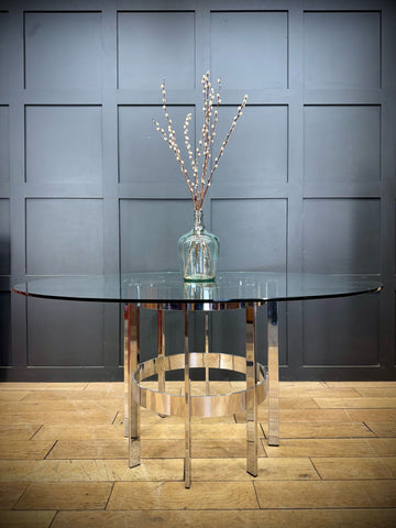 A sleek 1970s round glass top chrome dining table by richard young merrow associates with circular support rings