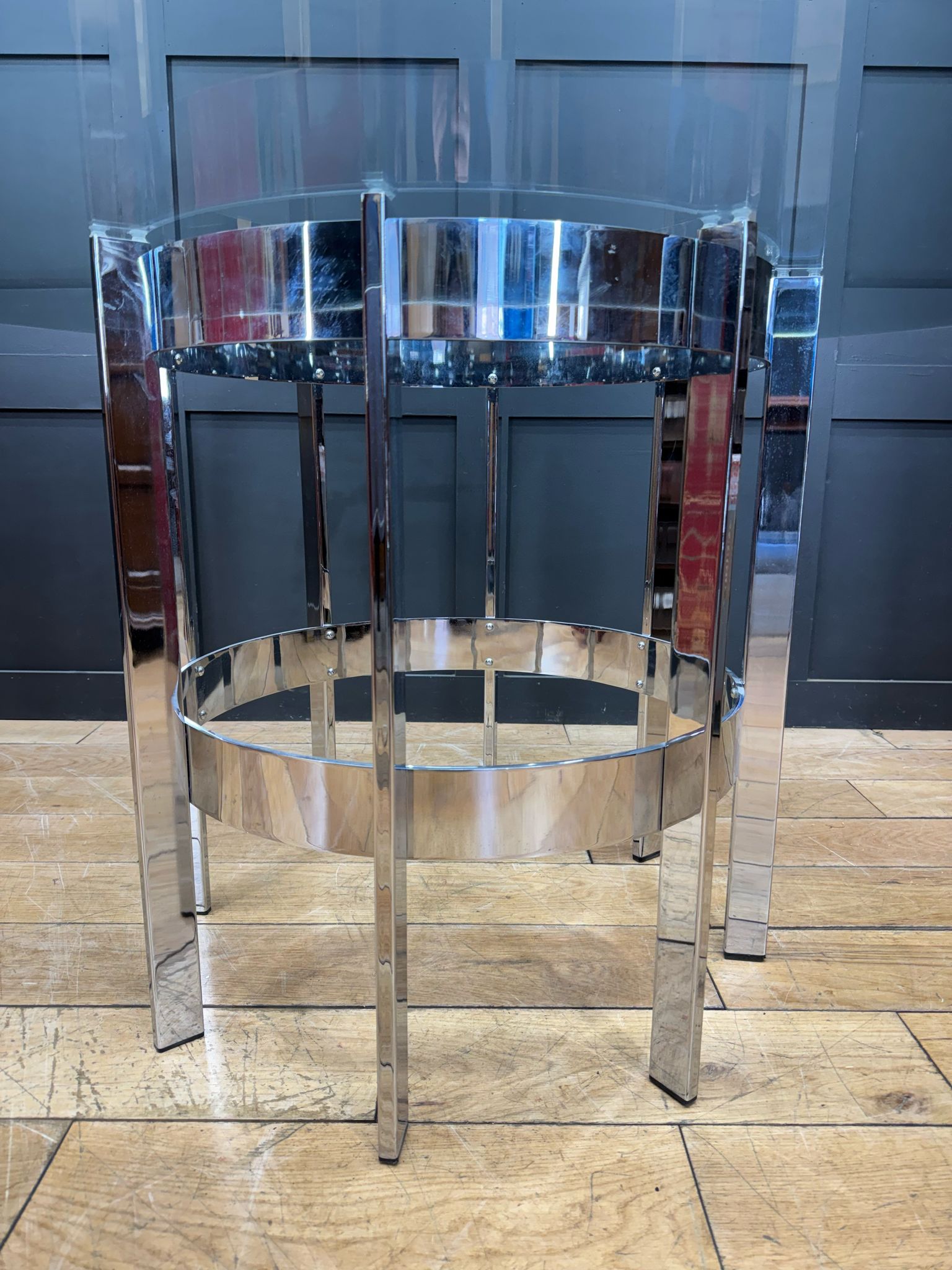Shiny chrome bar stool with circular glass top and mirrored legs complementing richard young merrow associates dining table