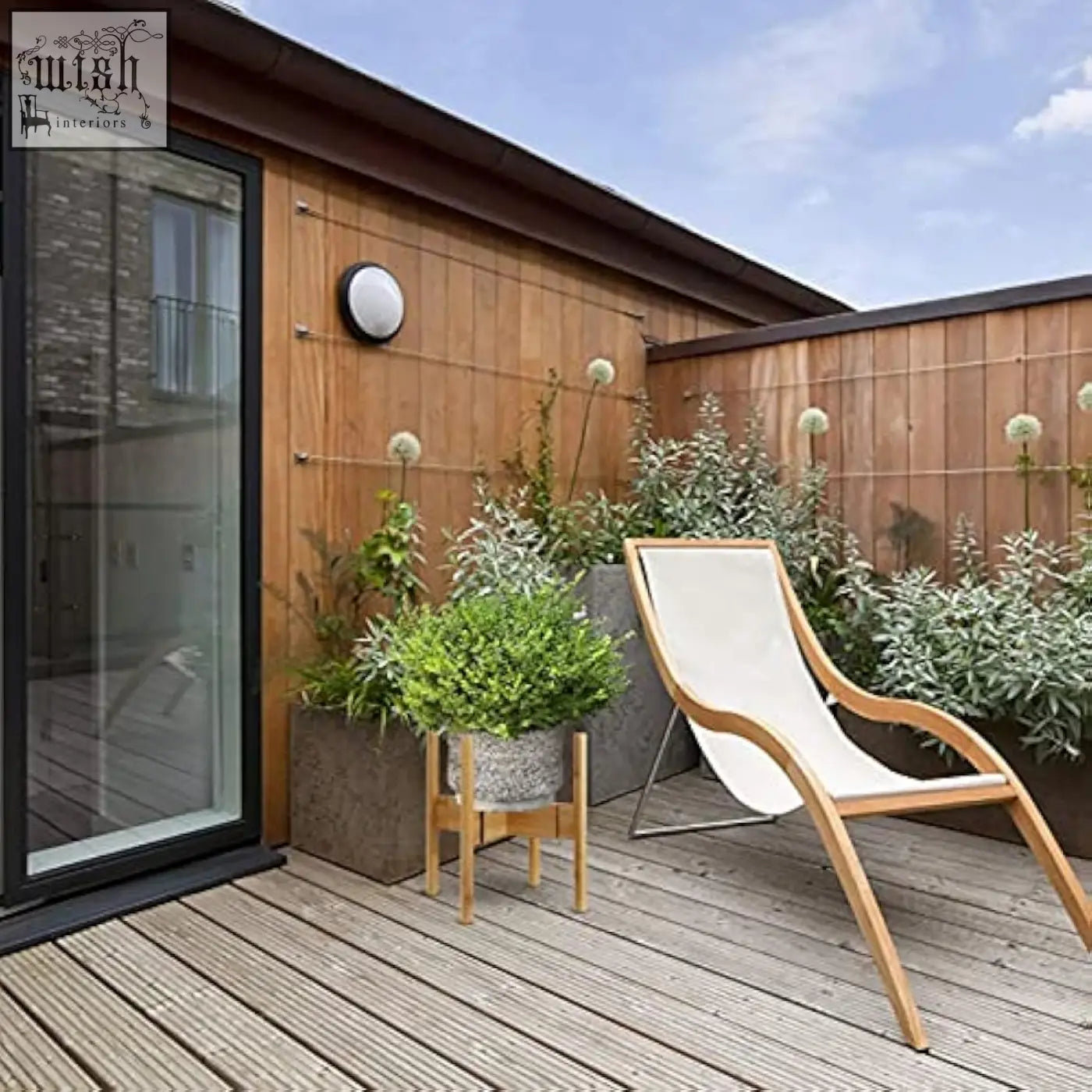 Modern wooden lounge chair with white fabric seat next to a bamboo adjustable plant stand flower pot holder