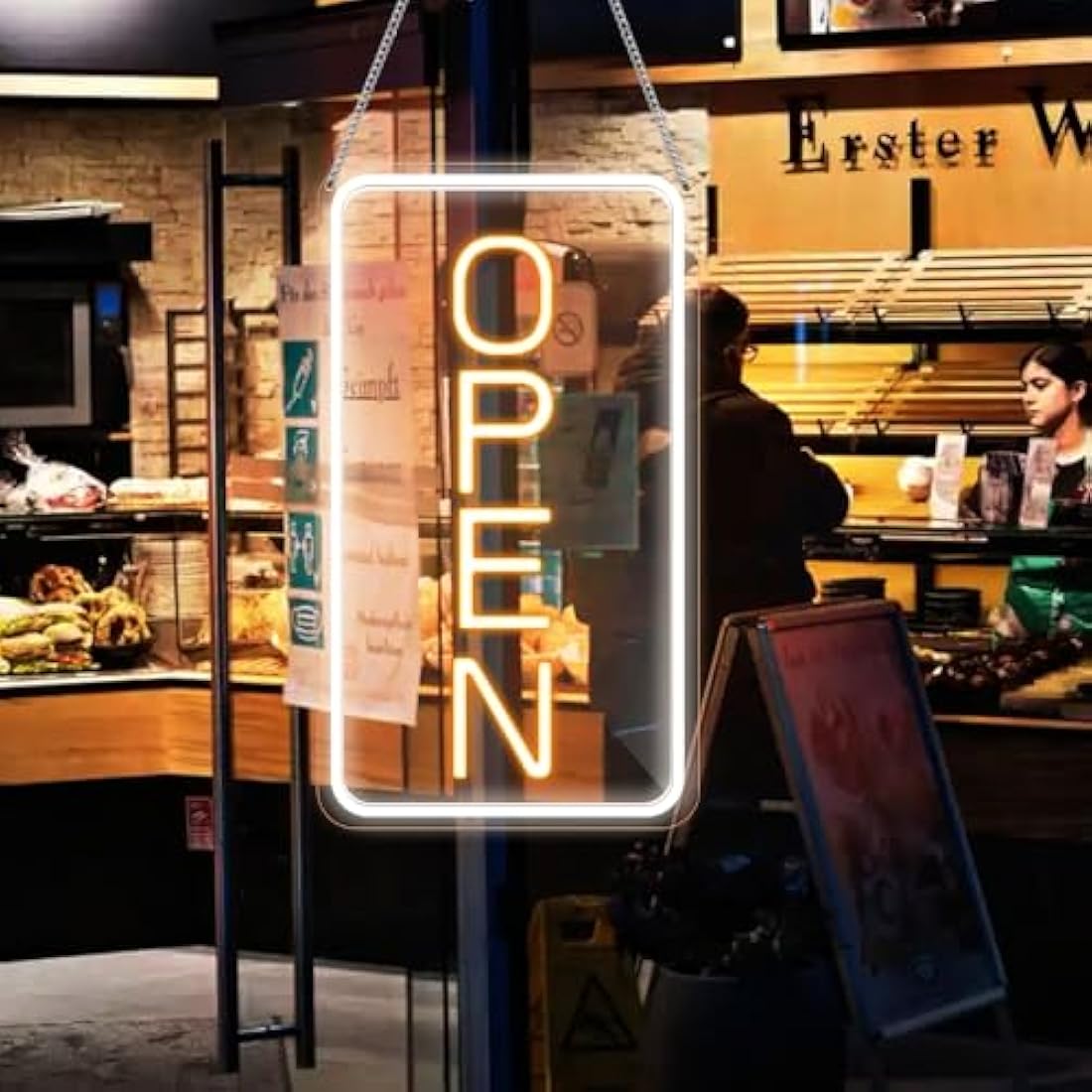 A glowing 22.8x11.8 led neon open sign in bright yellow-orange with white frame hanging from chains for business use