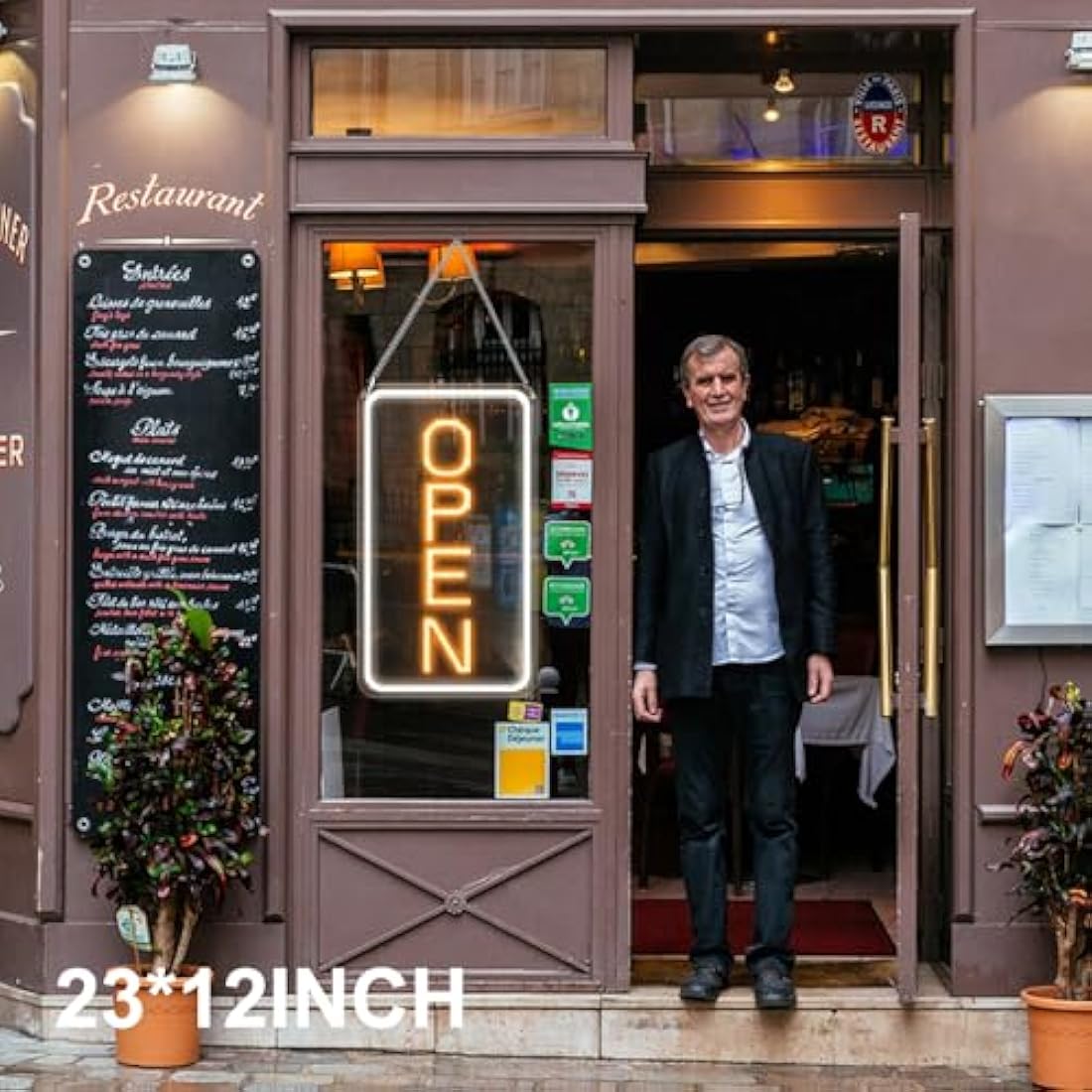 Glowing neon open sign with warm orange led light and rectangular frame hanging on a restaurant glass door