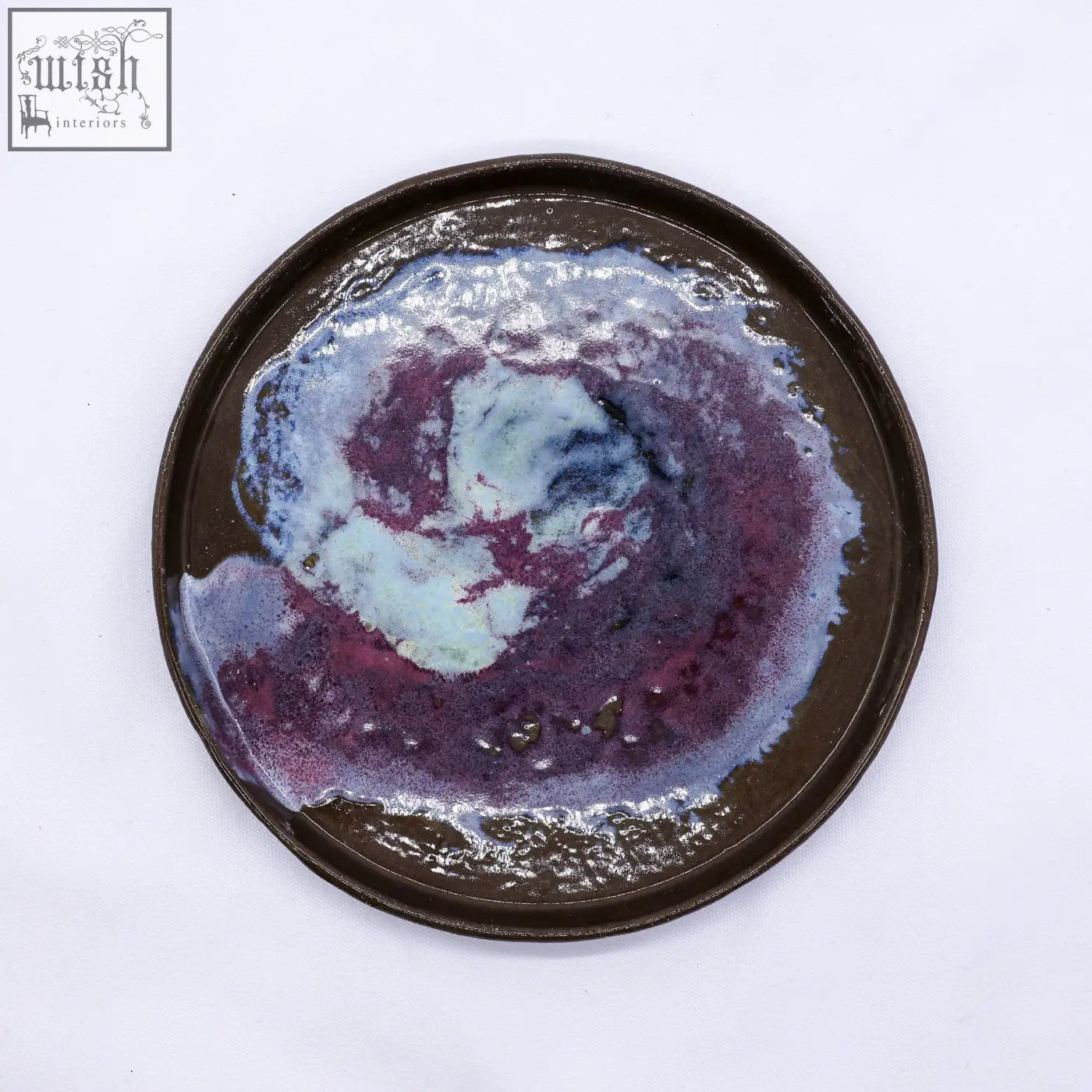 A 23 cm smoked grey large stoneware handmade ceramic dinner plate with a glossy purple and blue swirl glaze on dark brown base