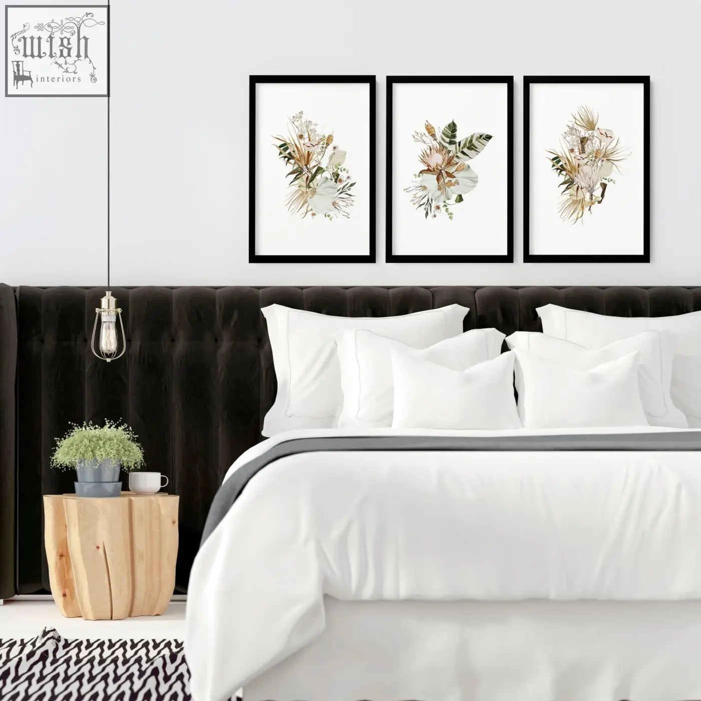 Three black-framed botanical art prints featuring delicate watercolor flowers hang as framed wall art above a bed