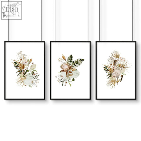 Set of 3 framed wall art featuring black frames and delicate beige and green botanical art prints above bed