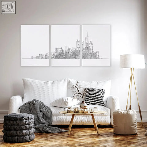 White sofa with textured fabric and matching throw pillows in living room with new york skyline wall art prints