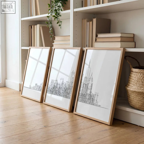 Three framed living room wall art prints with minimalist black new york skyline line drawings in light wood frames