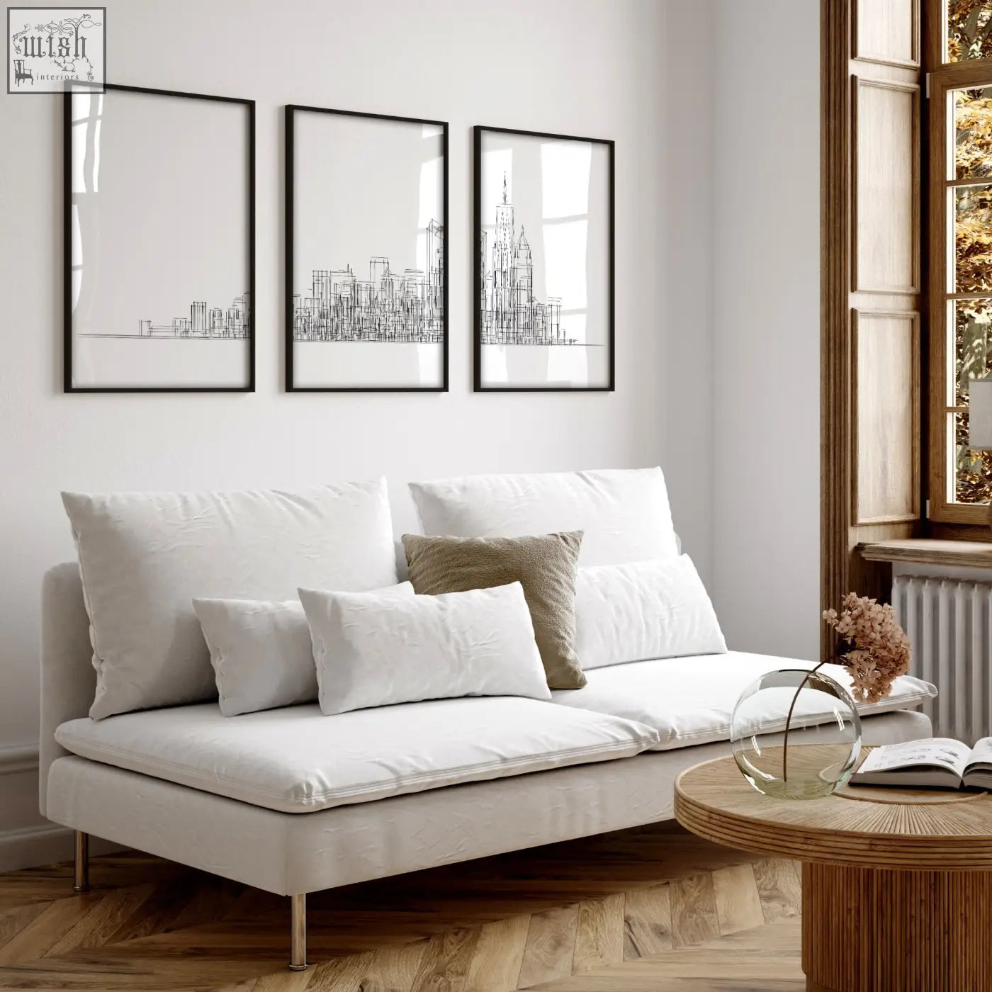 White upholstered sofa with metallic legs and cushions in living room with new york skyline wall art prints