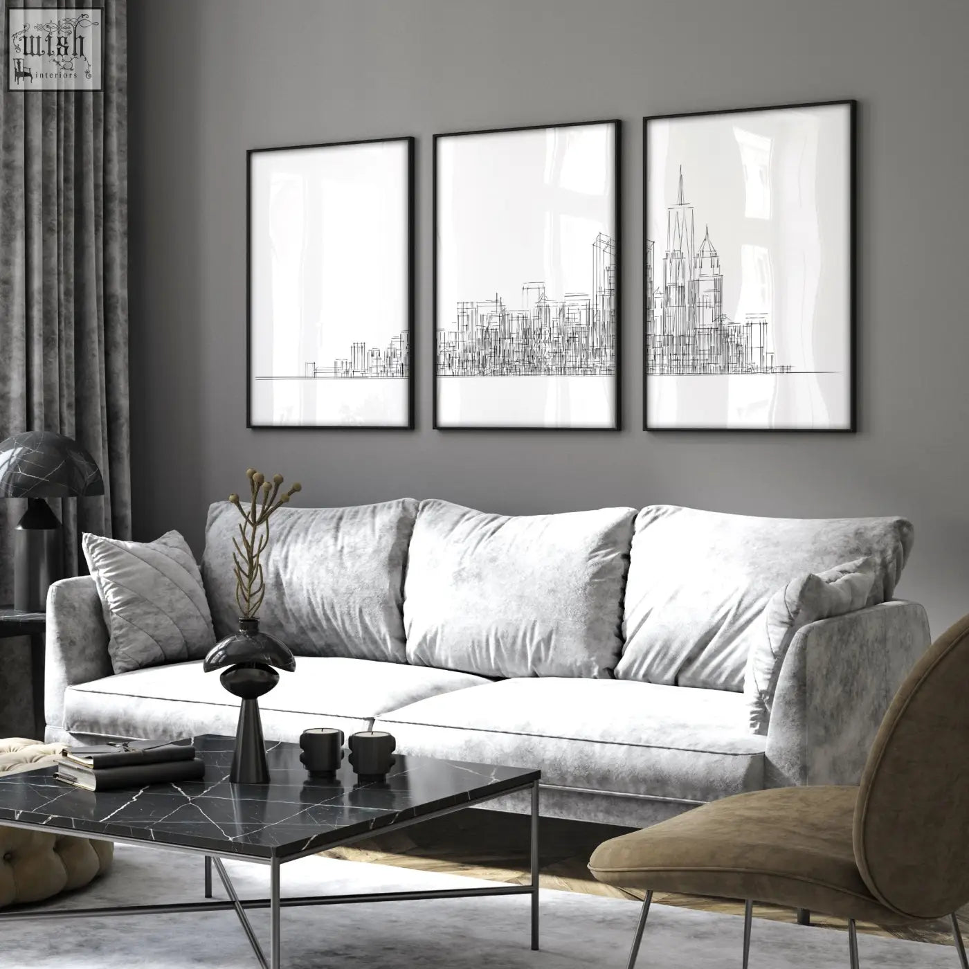 Three black-framed minimalist new york skyline wall art prints hang above a gray velvet sofa in a living room