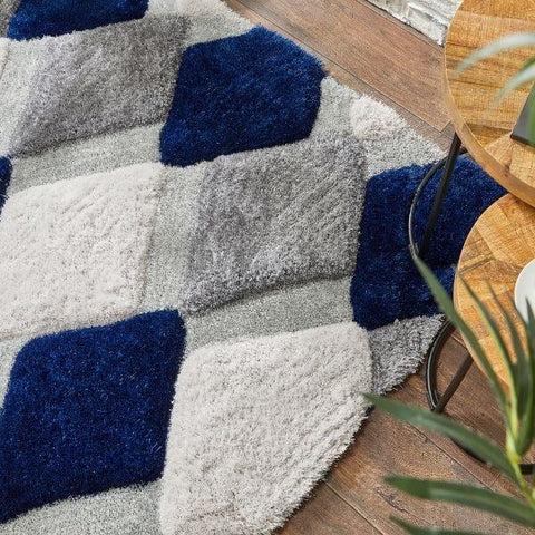 A plush navy geometric shaggy rug with gray and navy blue diamond-shaped patches for cozy living spaces