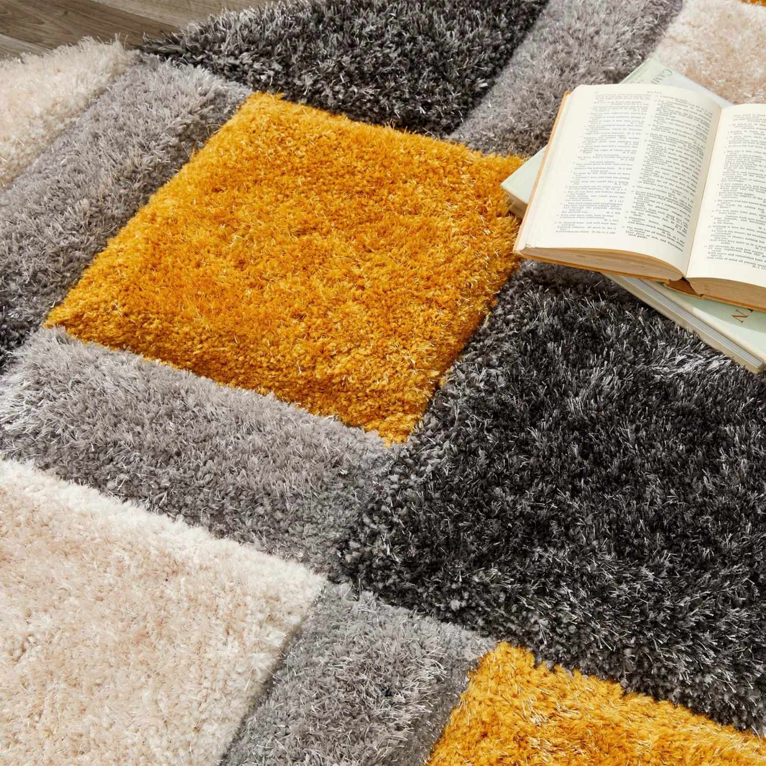 A plush geometric shaggy rug in shades of gray black and vibrant ochre geometric patchwork design