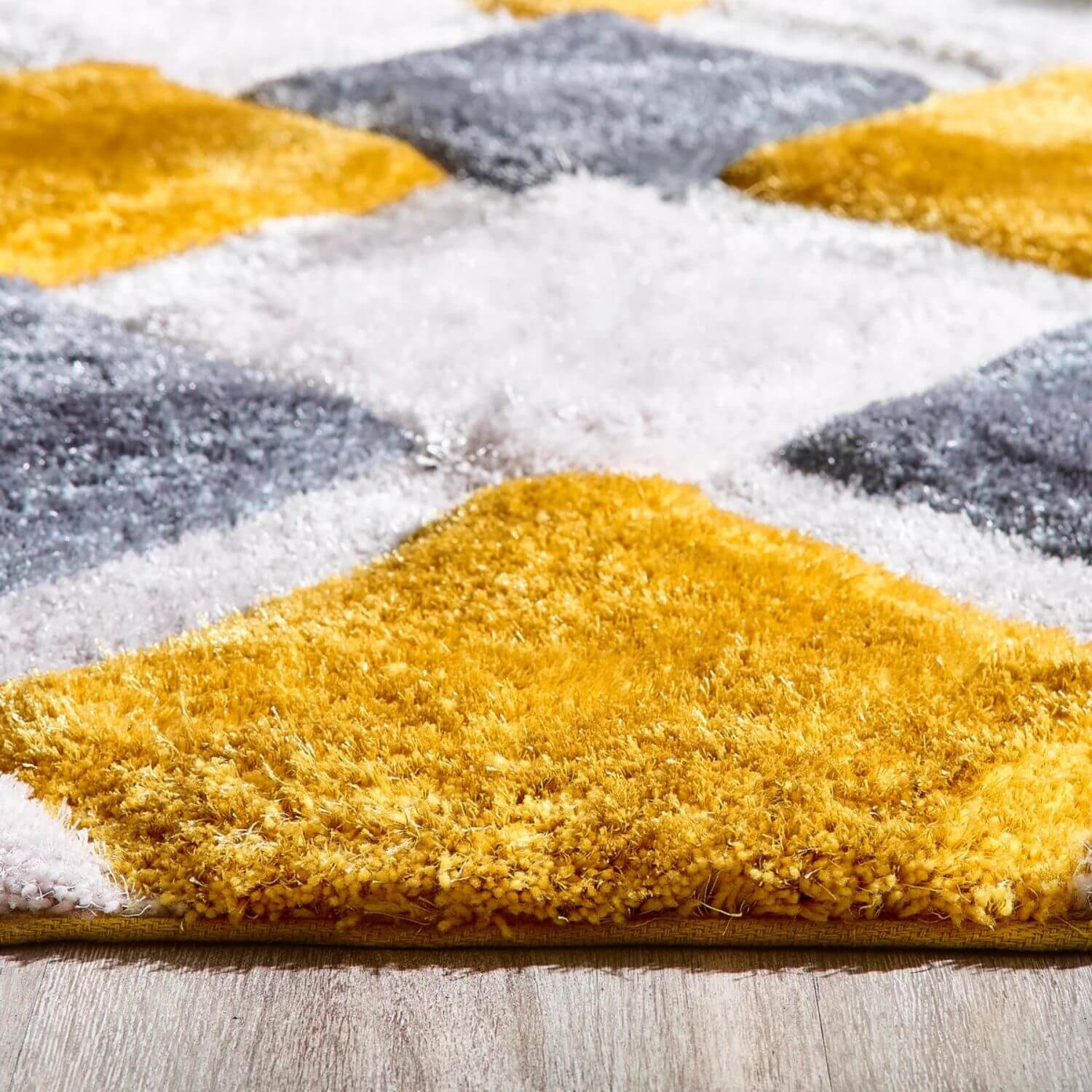 A plush ochre geometric shaggy rug with high-pile texture featuring mustard yellow charcoal gray and white squares