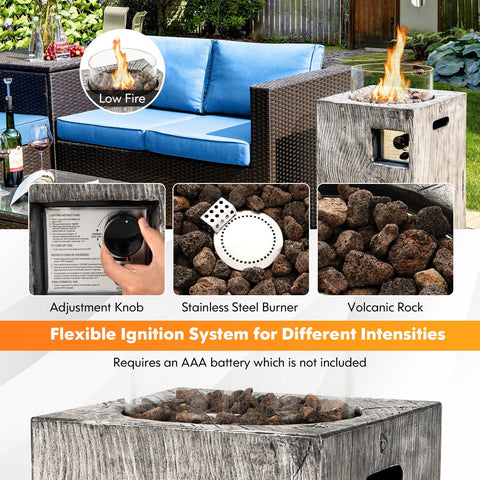 Weathered gray wooden pit table with glass wind guard filled with dark volcanic rock for outdoor use