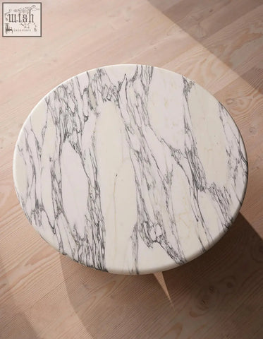 Abdurrahman round coffee table is a white marble coffee table with elegant gray veining perfect for any space