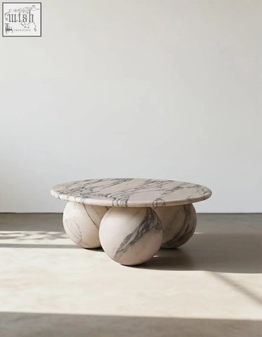 Abdurrahman round coffee table is a sleek white marble coffee table with gray veining and three rounded marble sphere legs