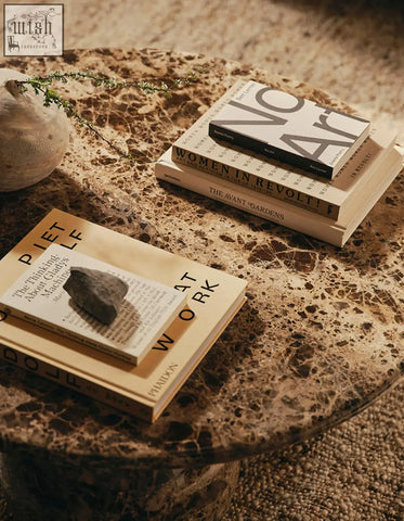 Stack of beige and black books on a speckled marble abdurrahman round coffee table perfect marble coffee table