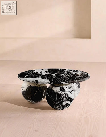 Abdurrahman round coffee table is a black and white marble coffee table with a sleek oval top and polished stone bases