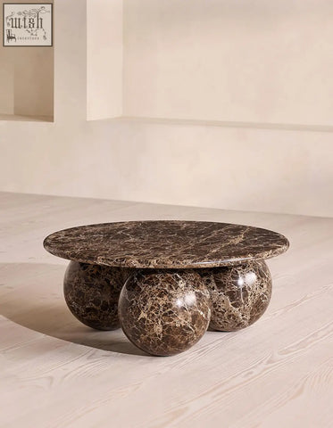 Abdurrahman round coffee table is a brown marble coffee table with a round top and three spherical legs