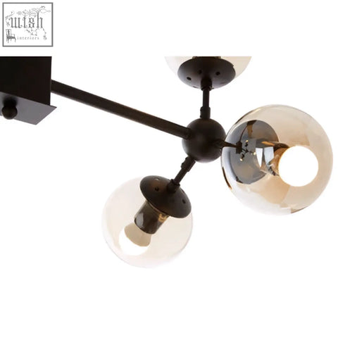 Matte black pendant light with six arms and three spherical glass globe shades perfect for modern spaces