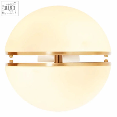 Abira brushed brass ball wall light with a warm cream glass dome and polished brass wall mount