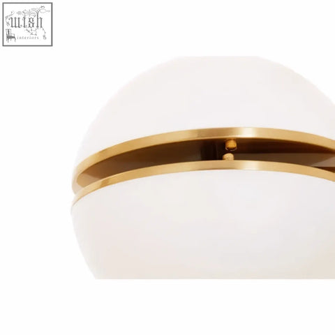 A sleek white opaline glass globe lamp with a polished brushed brass ring for a stylish brass wall light