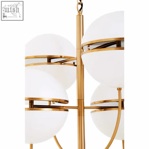 Gold-toned four ball brass pendant light with frosted white glass shades in a modern tiered design