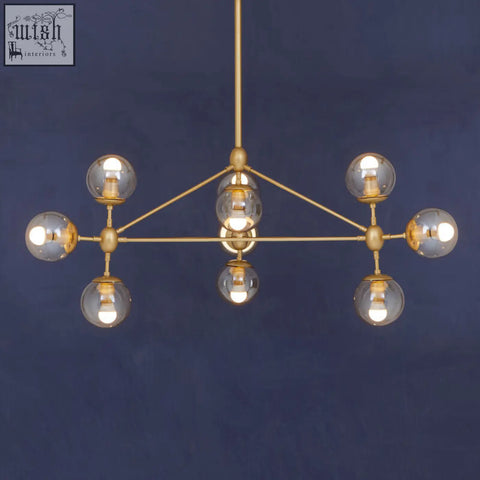 Abira gold 10 arm pendant light with six spherical glass bulbs in a geometric gold-toned arm pendant design