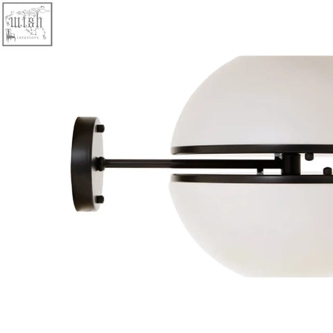 Black metal arm with matte finish supports off-white frosted glass globe in abira matt black ball wall light