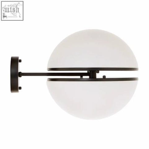 Abira matt black ball wall light featuring a black metal sconce with frosted white spherical glass shade