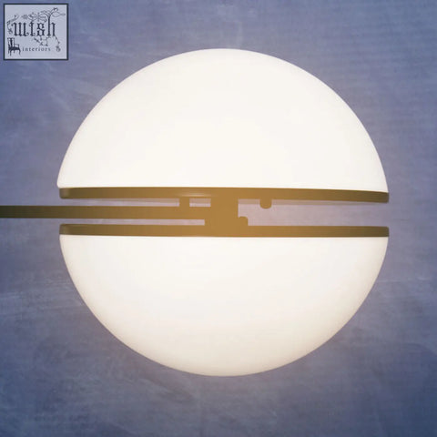 A sleek abira matt black ball wall light with frosted white glass dome and gold-toned metal bands