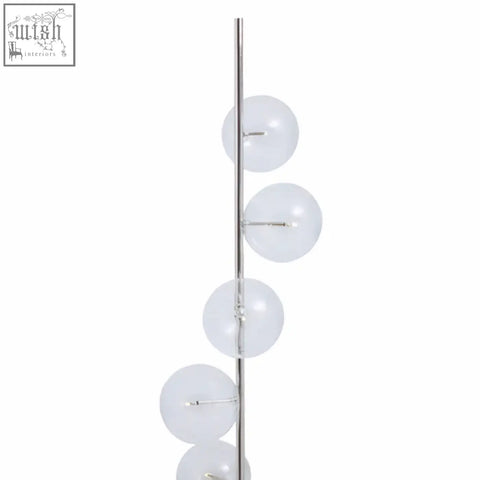 A sleek abira floor lamp with chrome finish, five glass globes, and a black marble base for stylish lighting