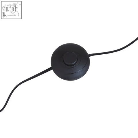 Black circular power switch with matte finish and cord on abira nickel and white marble floor lamp base