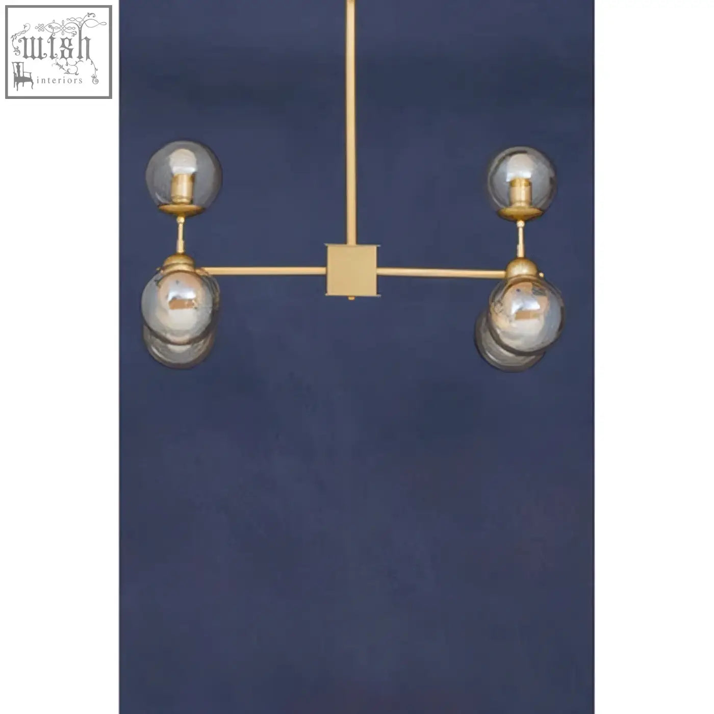 Gold-toned six arm pendant light with four glass globes on a minimalist geometric frame perfect for modern spaces