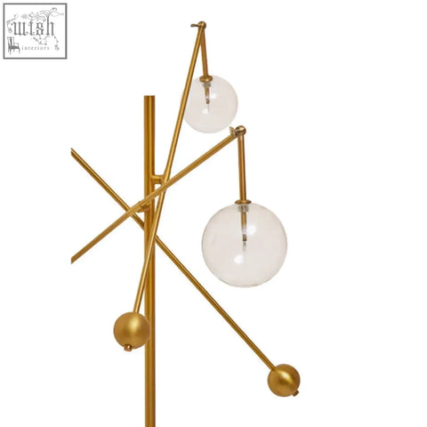 Abira three bulb floor lamp with gold-toned geometric design, clear glass shades, and polished metallic accents