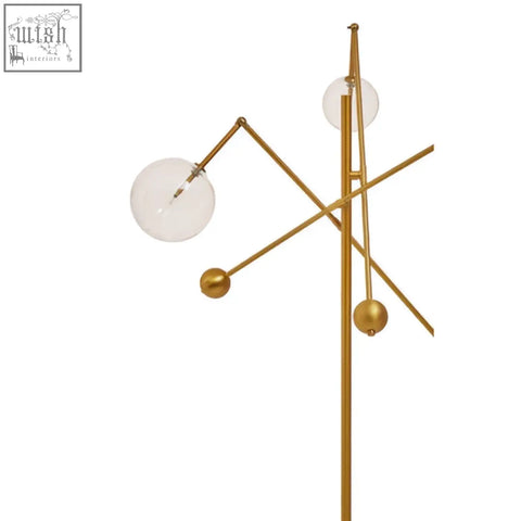 Gold-toned abira three bulb floor lamp with geometric design and clear glass globe shades featuring spherical accents