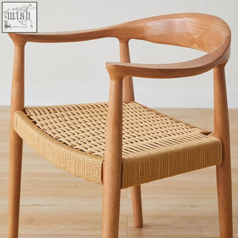 Abiram rattan dining chair with a light wood frame and woven natural fiber seat perfect for solid wood dining