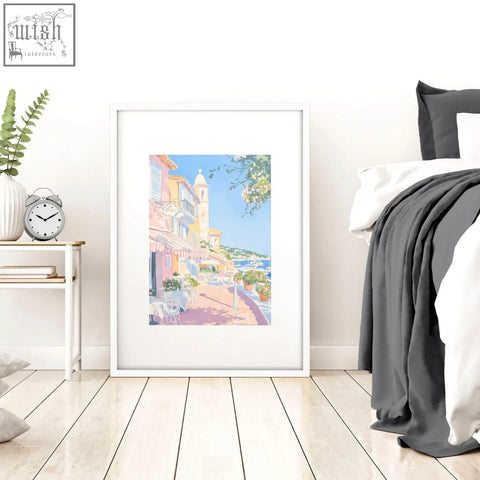 A framed watercolor wall art print of a colorful coastal street in pastels perfect for bed wall decor set of 3