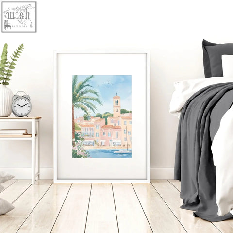 A framed watercolor wall art print of pastel pink coastal town with palm trees for above the bed wall decor set