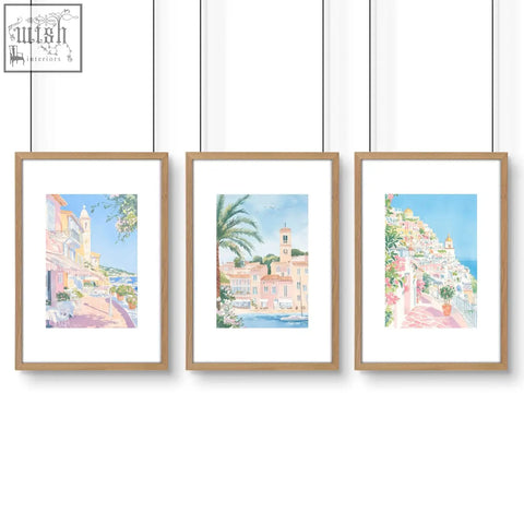 Set of 3 watercolor wall art prints of mediterranean coastal towns in light wood frames perfect for bed wall decor