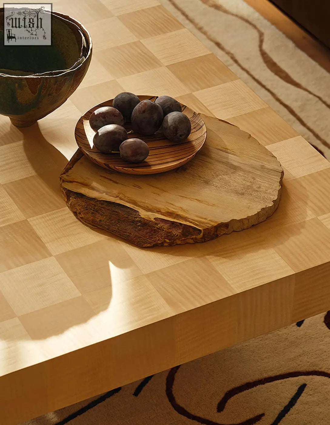 A rustic circular wooden serving board with natural edge and grain paired with abrahams rectangle coffee table wood