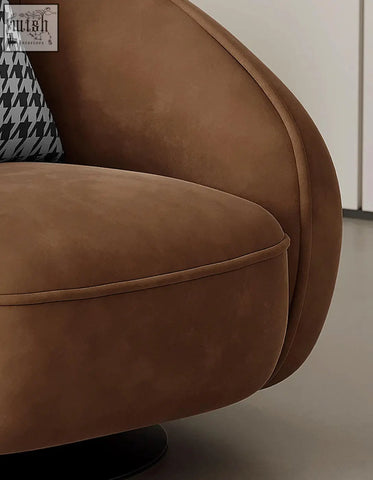 Brown suede abreu swivel accent chair with curved plush design and black and white houndstooth pillow round armchair