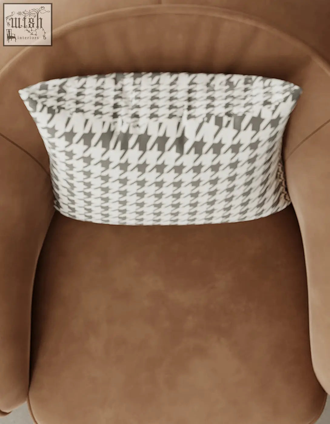 A rectangular gray and white houndstooth cushion on a tan abreu swivel accent round armchair